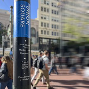 Pedestrian wayfinding in the heart of San Francisco wrapping the existing light poles.
